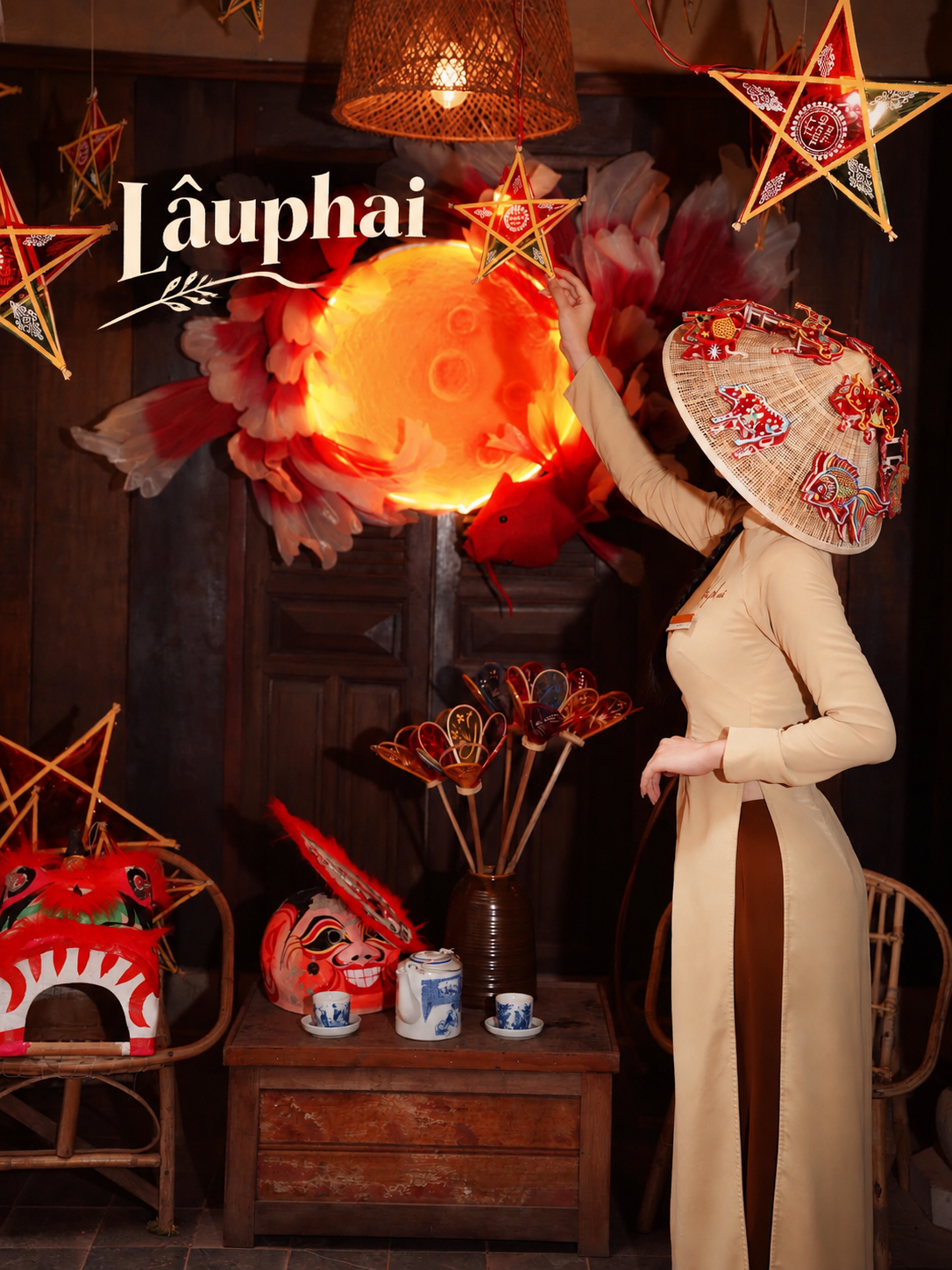 Woman in áo dài and decorated conical hat beside a glowing moon, star lanterns and a lion dance head at Lâuphai in Da Nang for Mid-Autumn