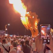 Dragon Bridge Da Nang breathing fire during the weekend show, with crowds watching from the riverbank