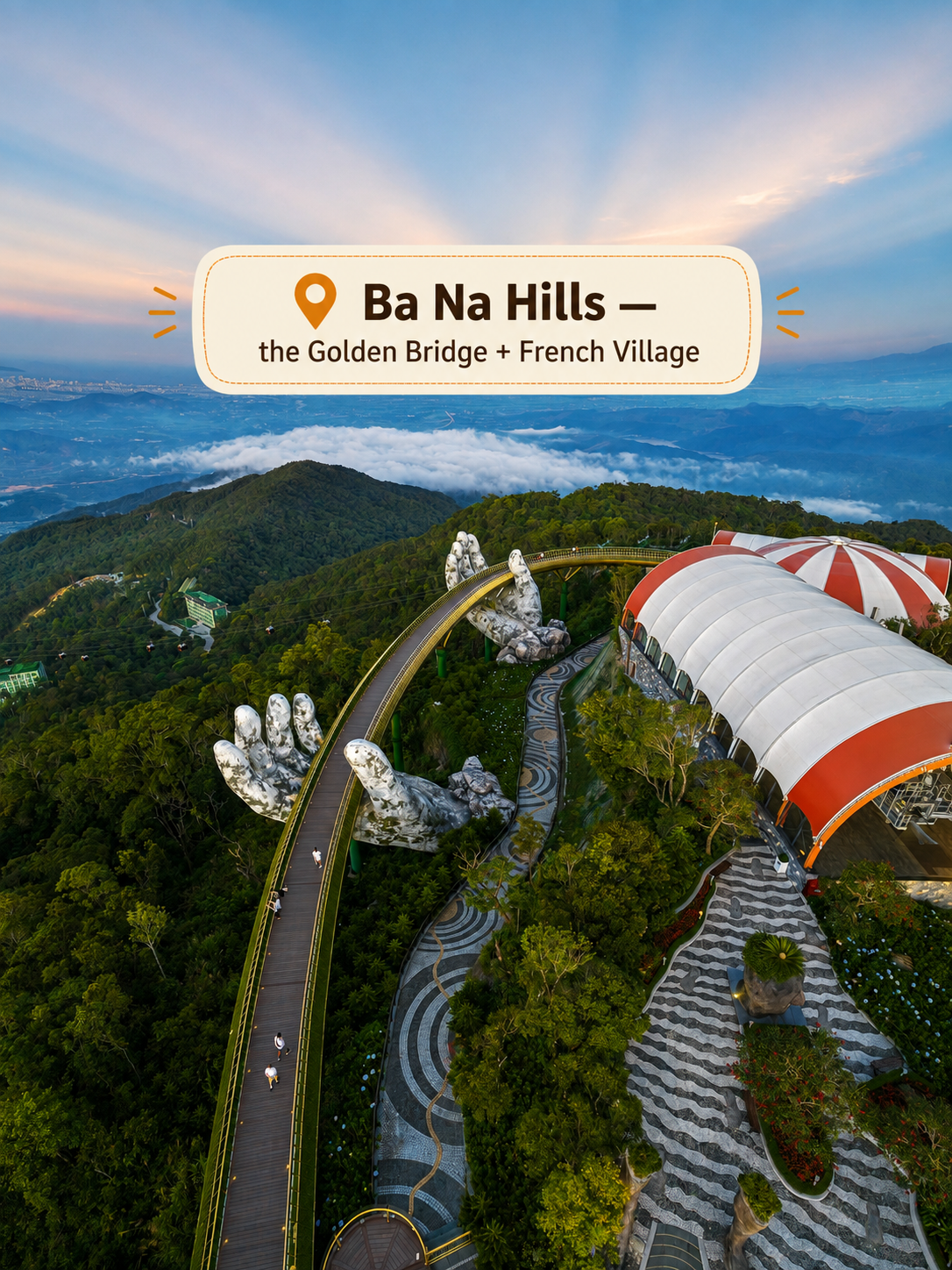 Aerial view of the Golden Bridge held by giant stone hands at Ba Na Hills near Da Nang, with the French Village and mountains behind