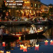 Floating flower lanterns on the Thu Bon River in front of the lantern-lit Hoi An Ancient Town at night