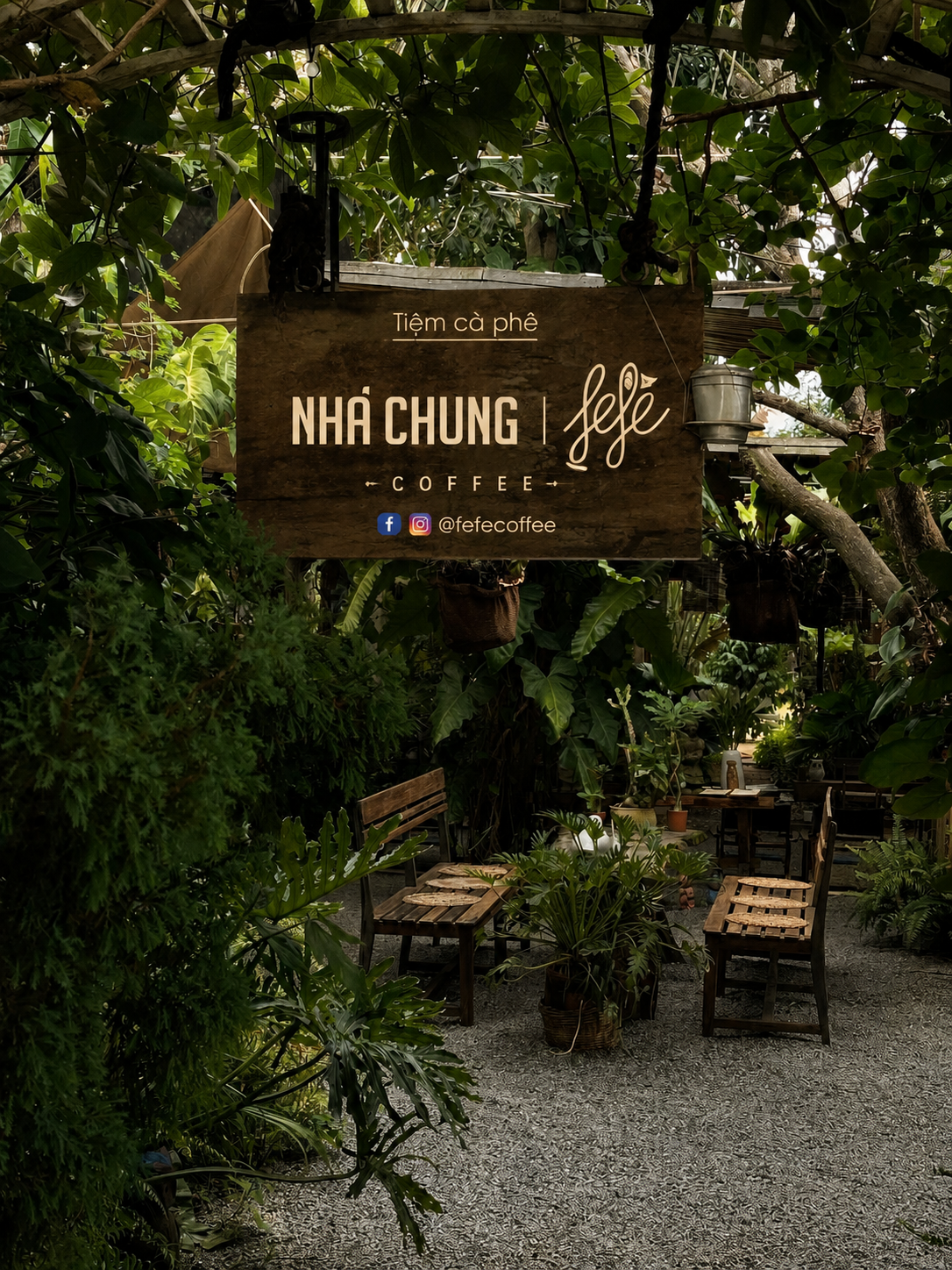 Nha Chung Fefe Coffee in Hoi An, a lush jungle-like garden with benches and a wooden sign