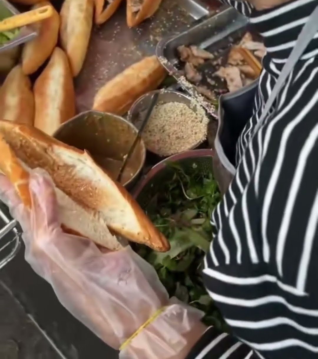 A bánh mì being filled at the morning street cart at 51 Phạm Hồng Thái, Da Nang