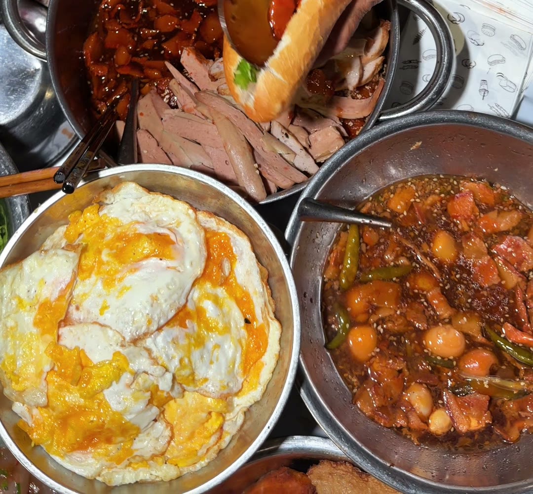 Bánh mì being filled at the late-night street cart at 118 Nguyễn Chí Thanh, Da Nang, with fried eggs and braised pork with eggs