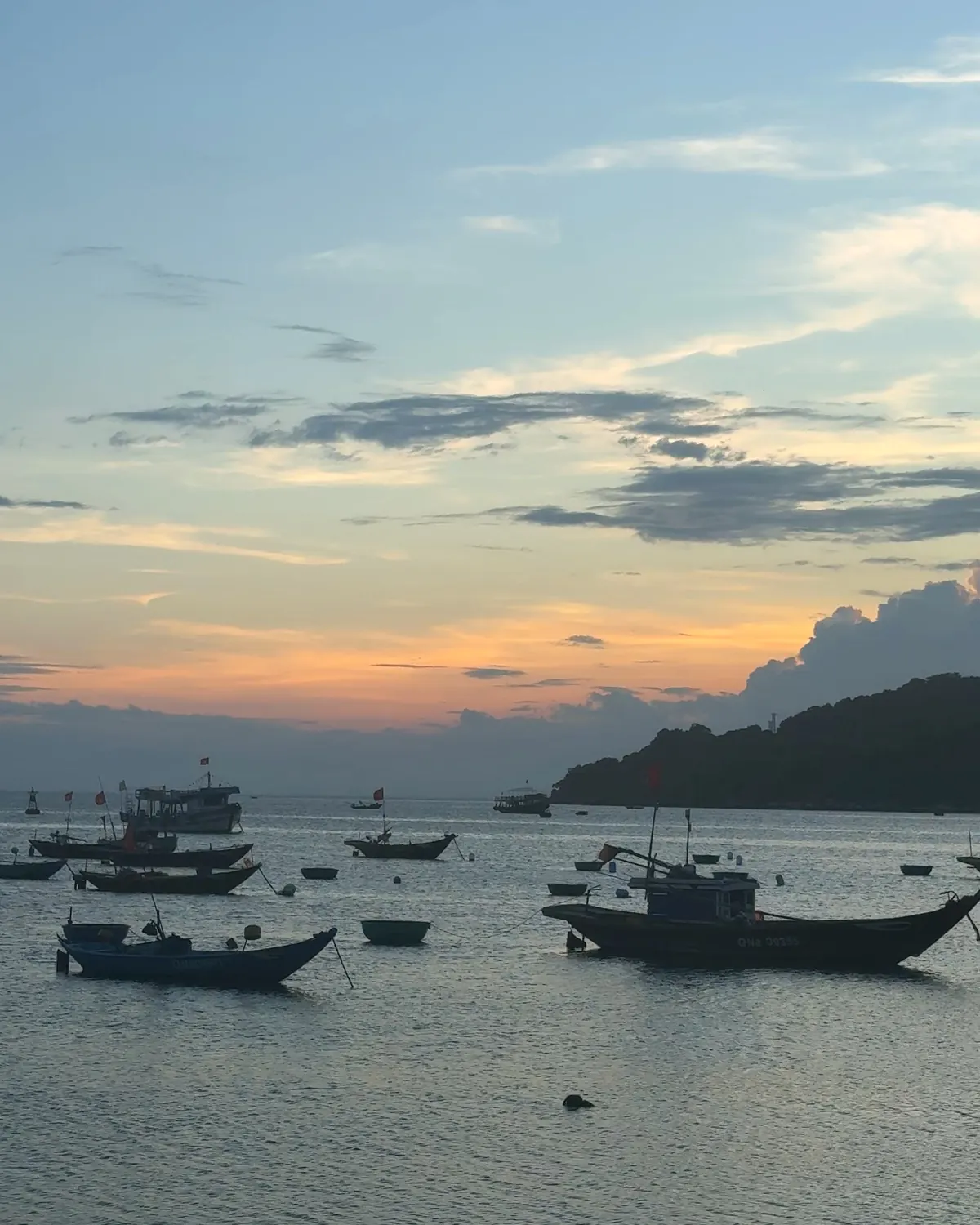 Fishing boats anchored in a calm bay at sunset on Cù Lao Chàm