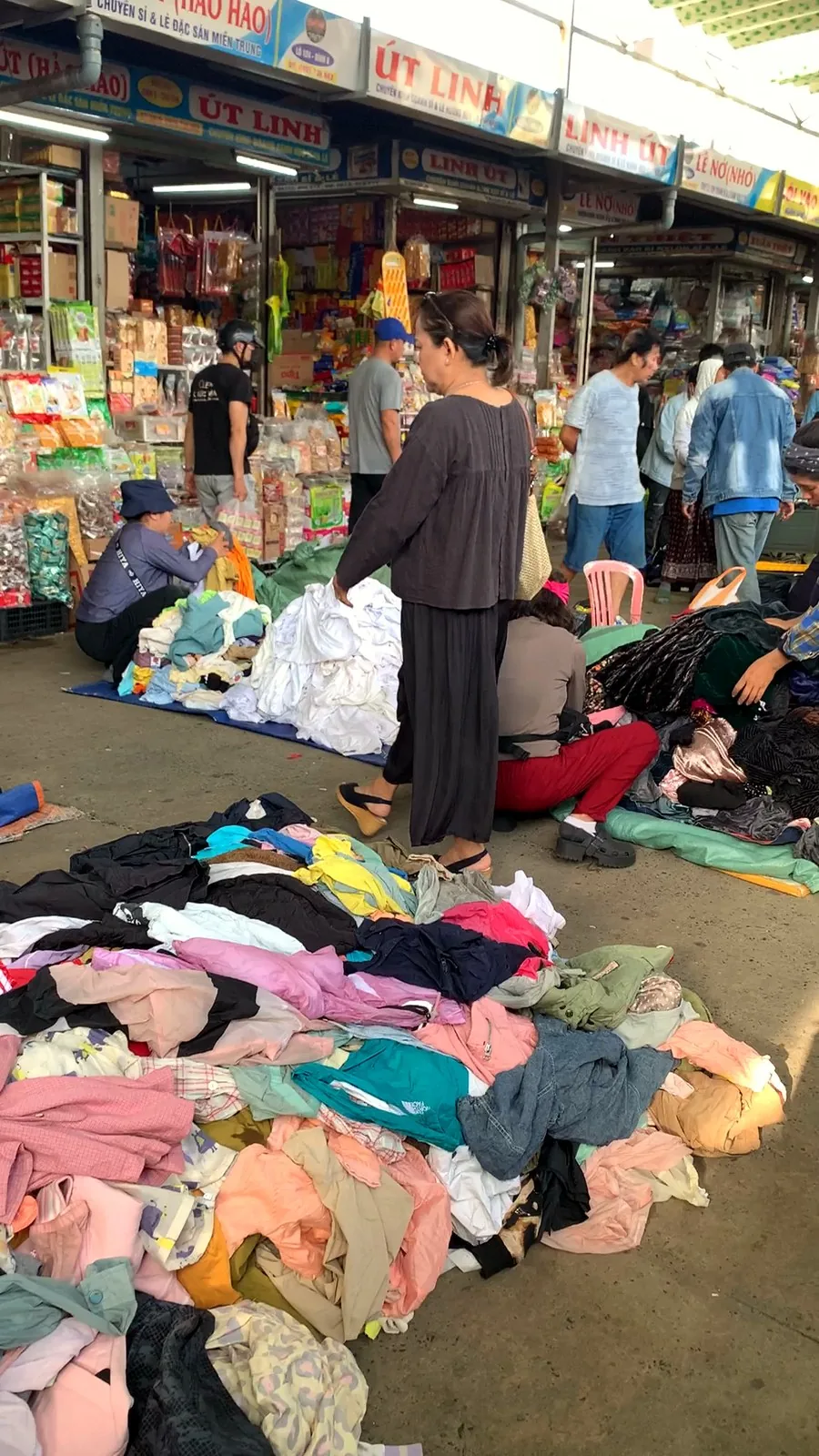 Piles of clothes on the floor of Con Market as shoppers sort through them
