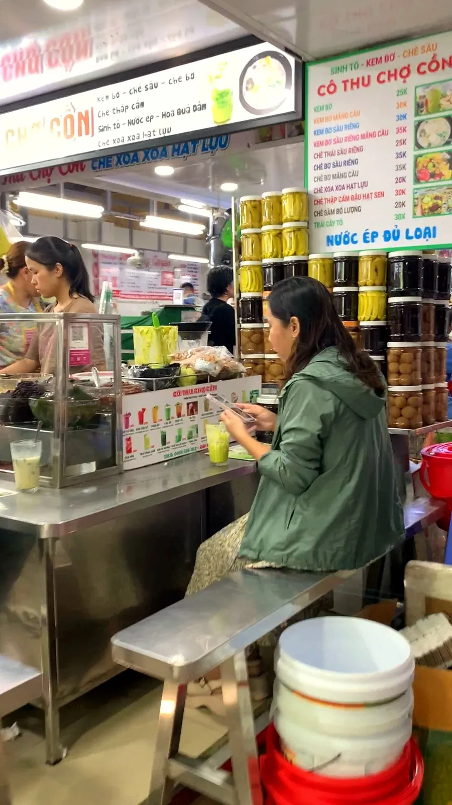 The Cô Thu Chợ Cồn dessert stall with its price board for kem bơ and chè, and rows of jars on the counter
