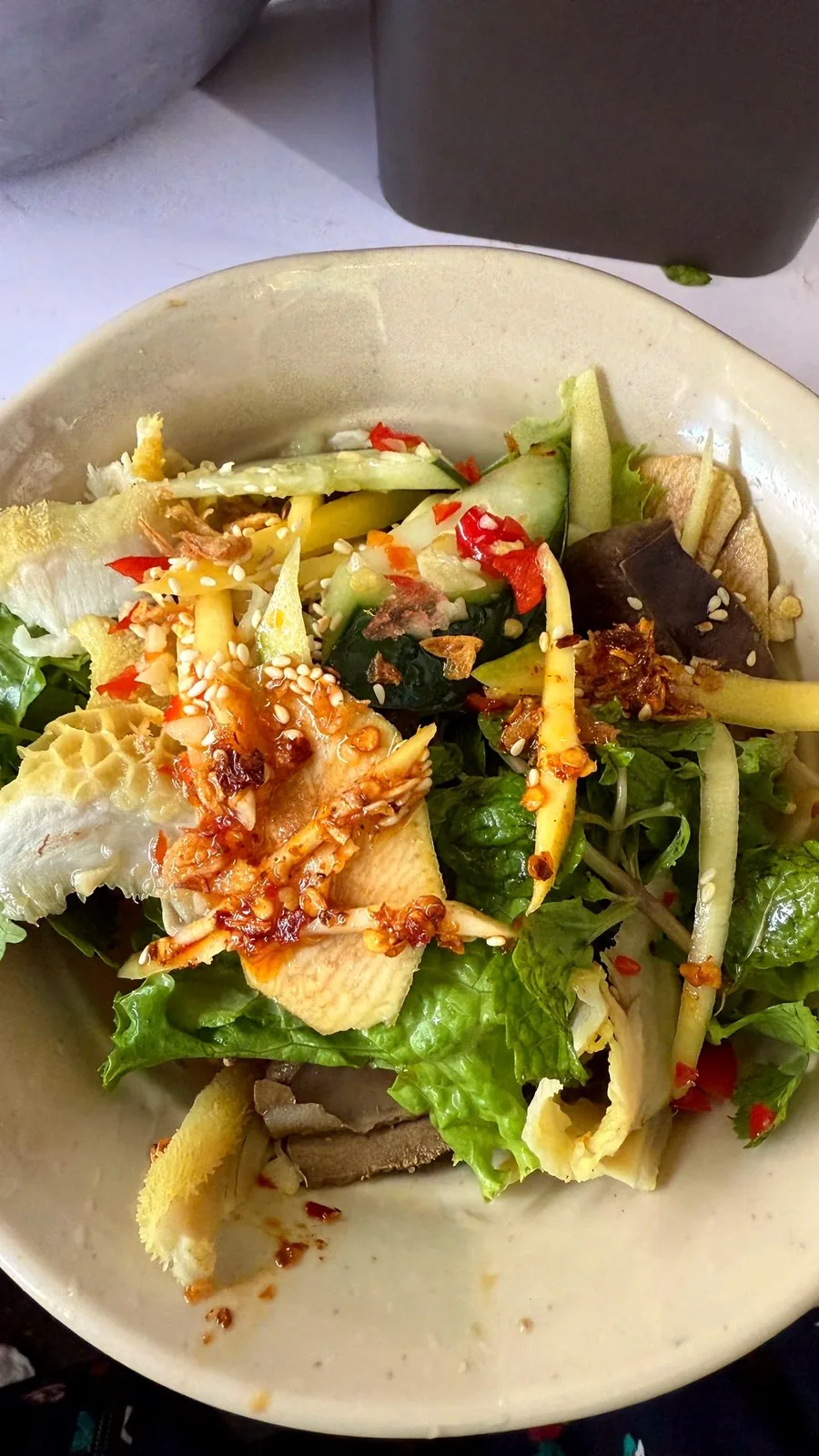 A bowl of Da Nang-style phá lấu trộn at Con Market: sliced offal with green mango, cucumber, herbs, chili and sesame