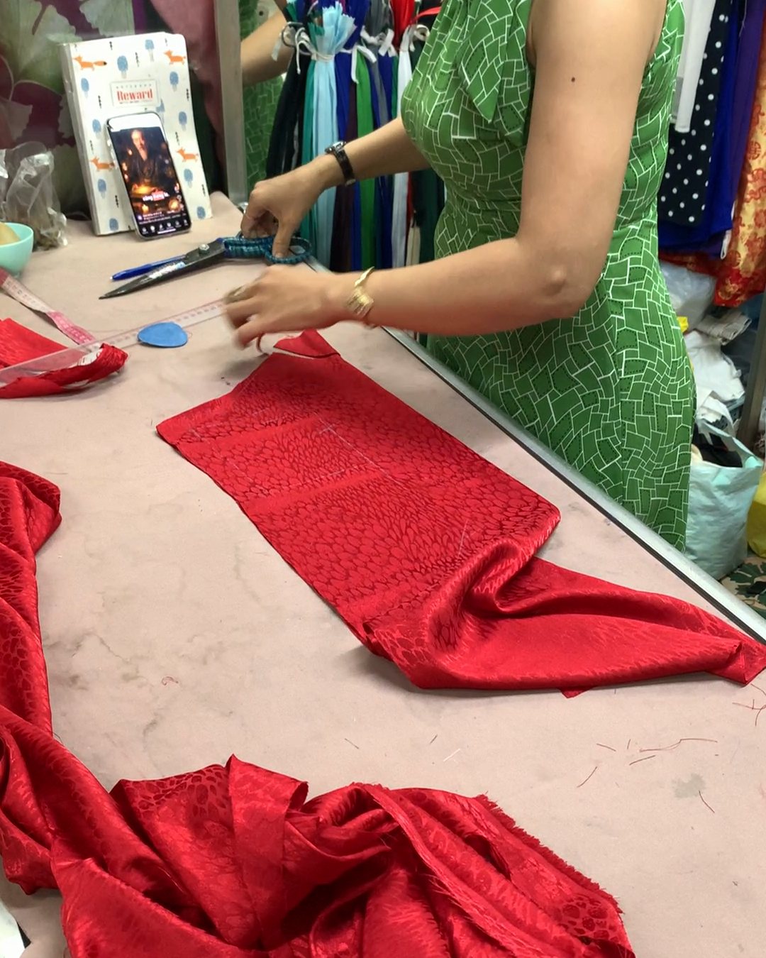 A tailor cutting red silk for an áo dài at Han Market Da Nang