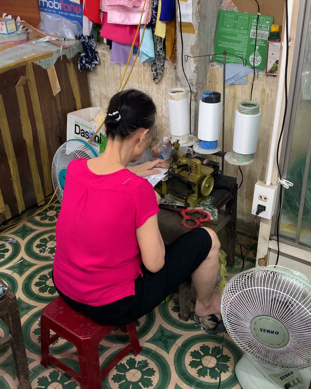 A seamstress sewing in her stall on the 2nd floor of Han Market