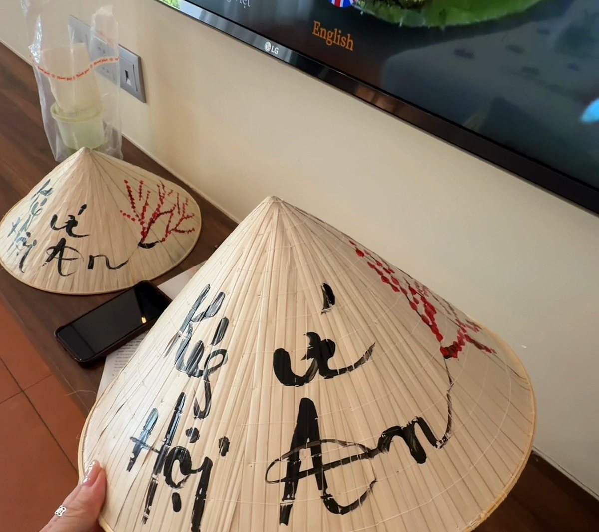 Two conical hats with Ký Ức Hội An painted in black calligraphy, the gift for guests at Hoi An Memories Land