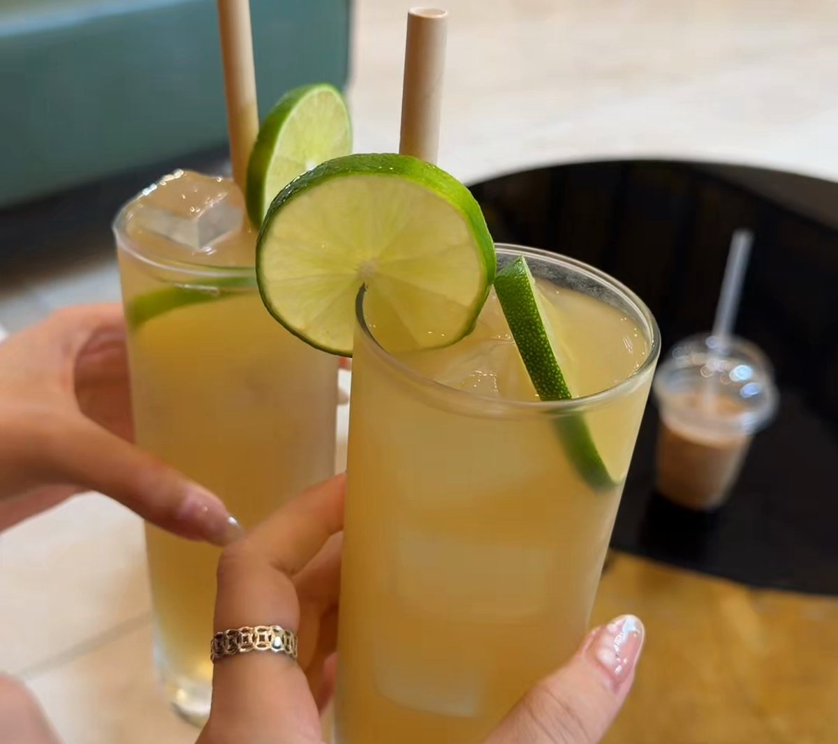 Two glasses of iced lemongrass and lime drink being clinked together at Hoi An Memories Land