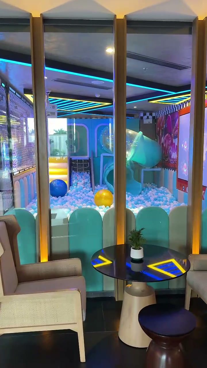Colourful indoor play area with a ball pit and slide at the Hoiana kids club