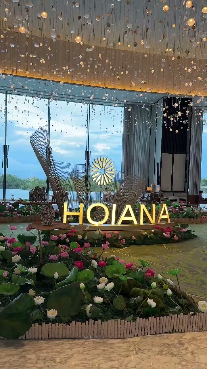 HOIANA sign and lotus flower display under a crystal chandelier in the hotel lobby at Hoiana Resort & Golf