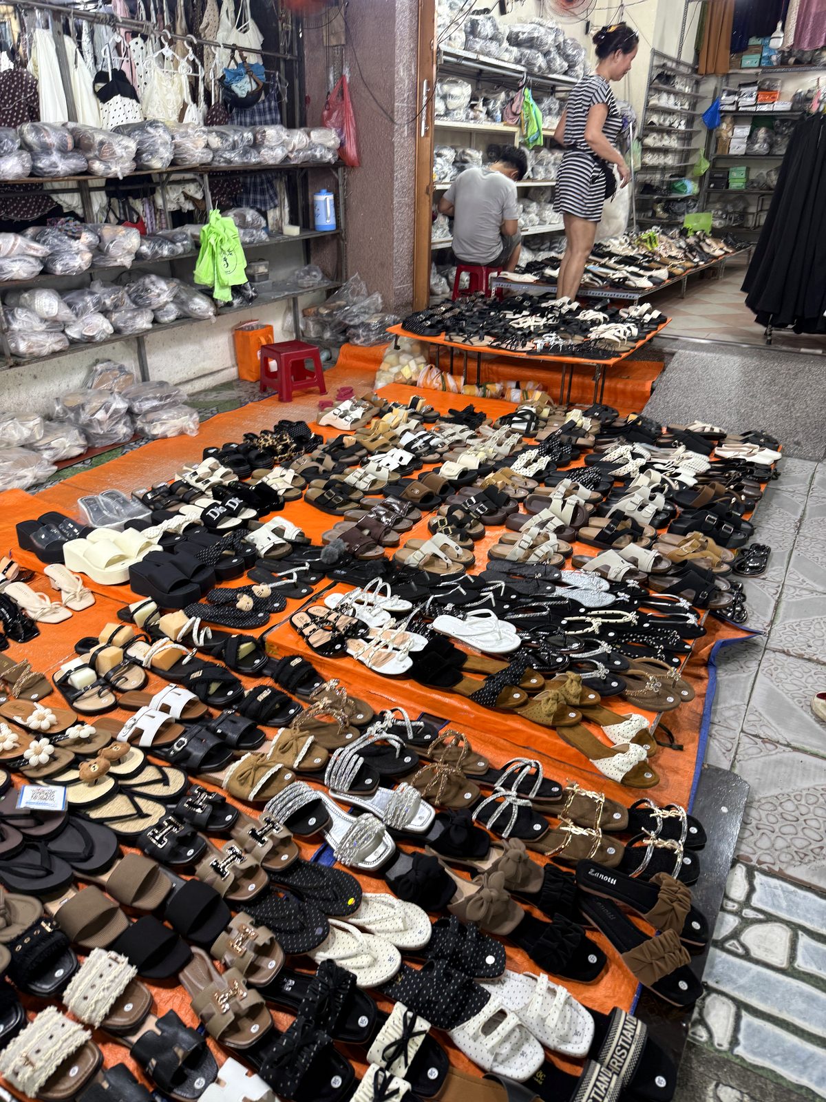 Rows of sneakers and sandals laid out at a shoe stall in Le Duan Night Market, Da Nang