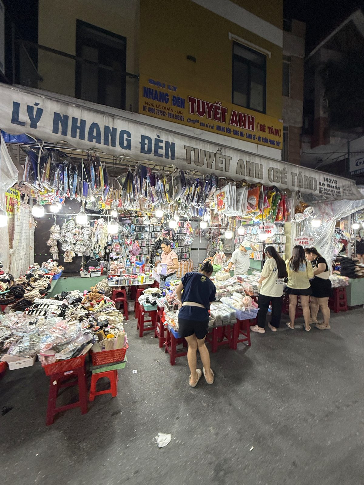 Brightly lit clothing stalls along the alley at Le Duan Night Market, Da Nang