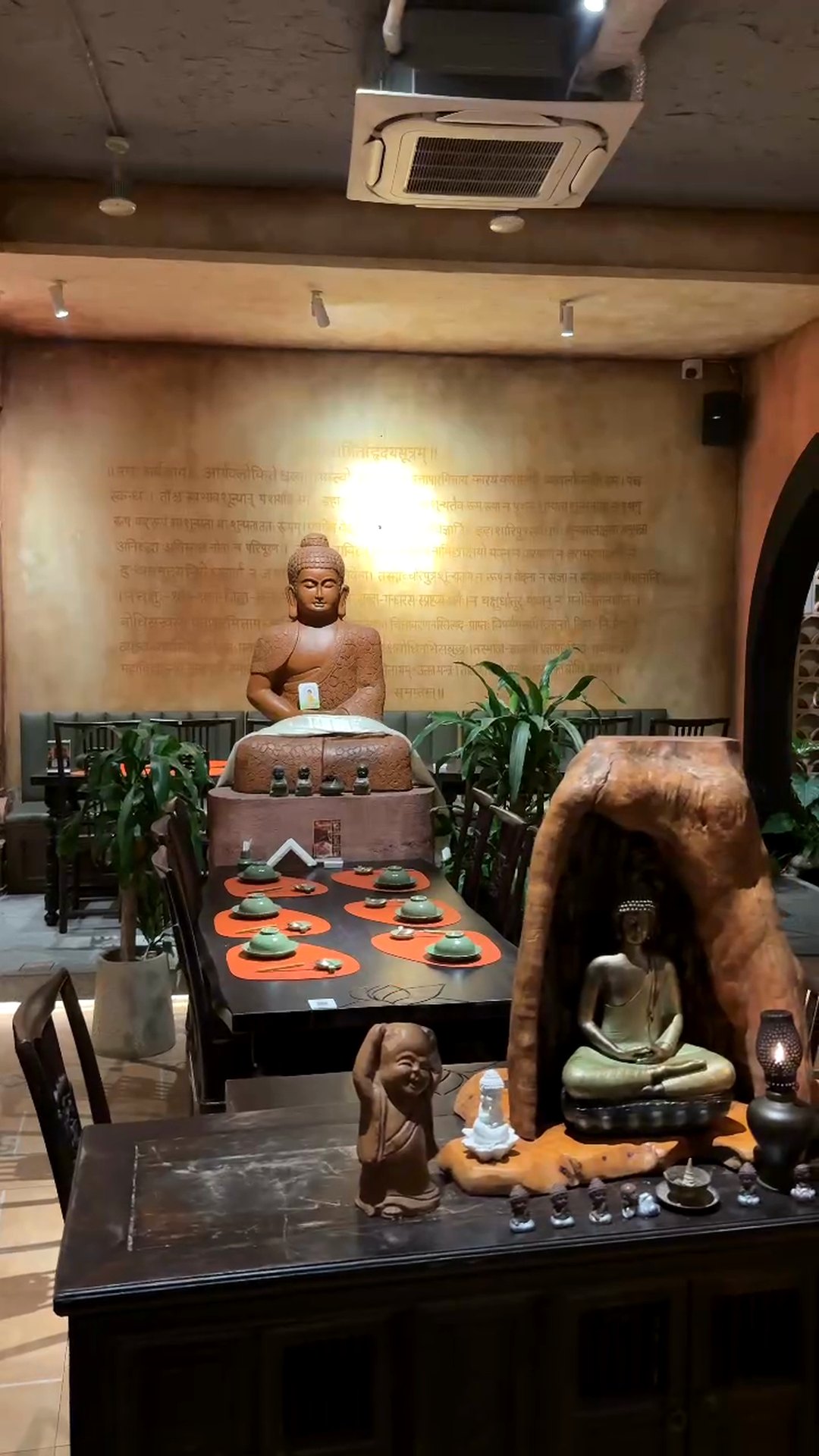 Dining room with a Buddha statue and warm lighting at Maha Vegetariano