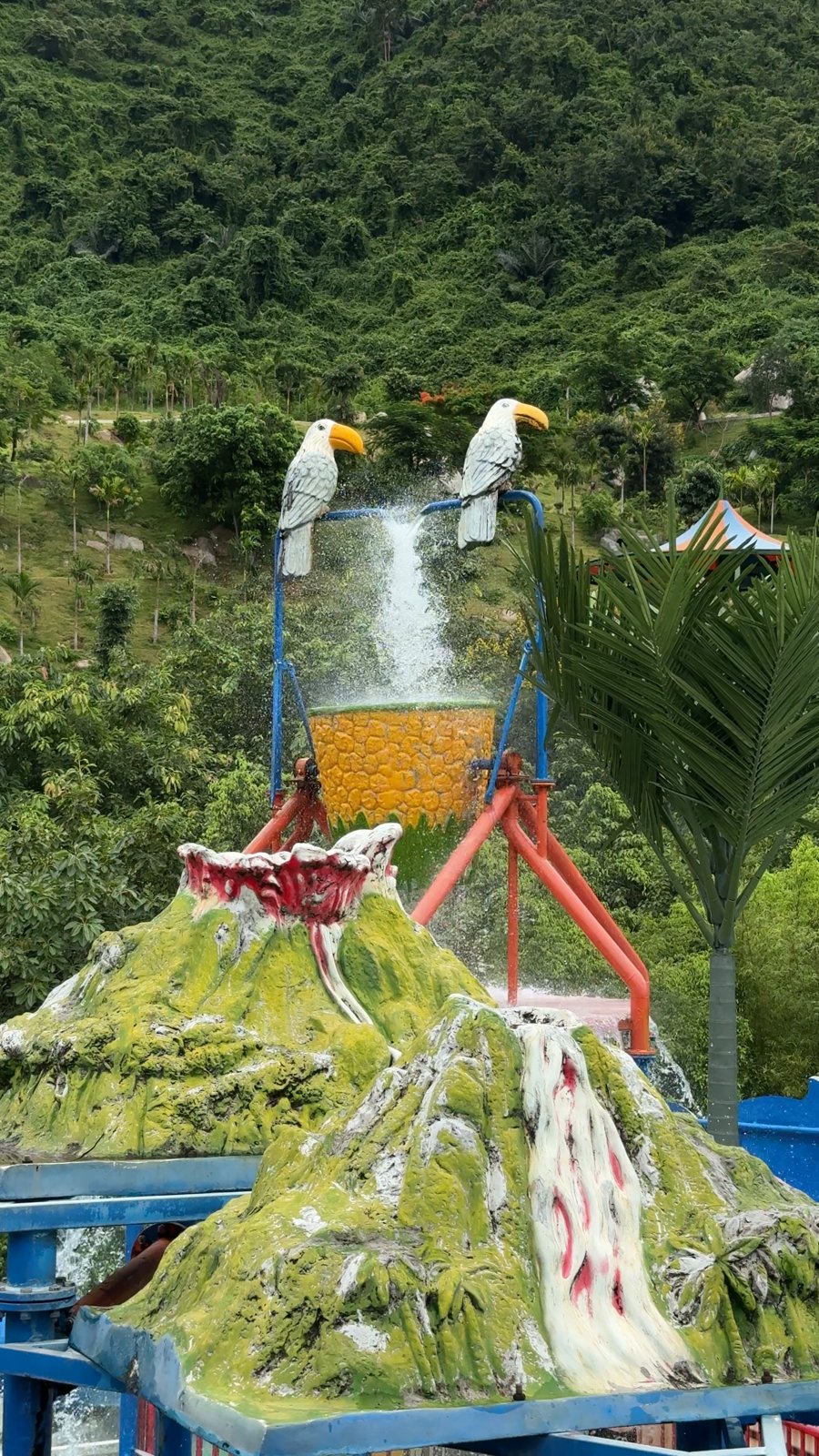 Volcano waterfall and bird statues at Núi Thần Tài Hot Springs Park water park, Da Nang