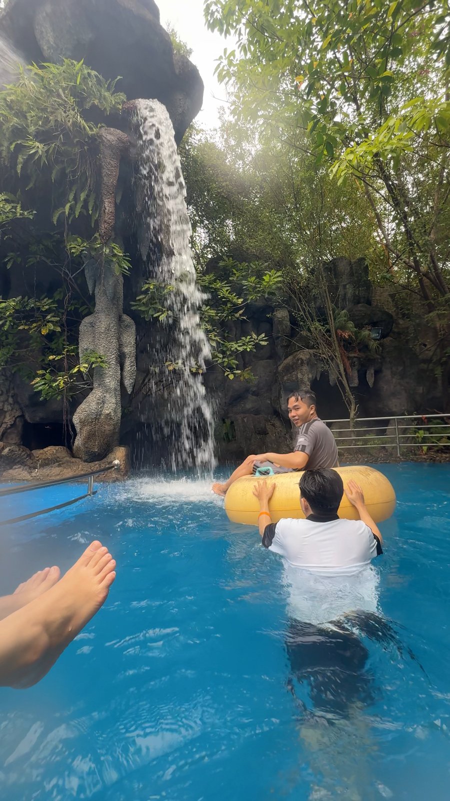 Lazy river with tubes under a waterfall at Núi Thần Tài Hot Springs Park
