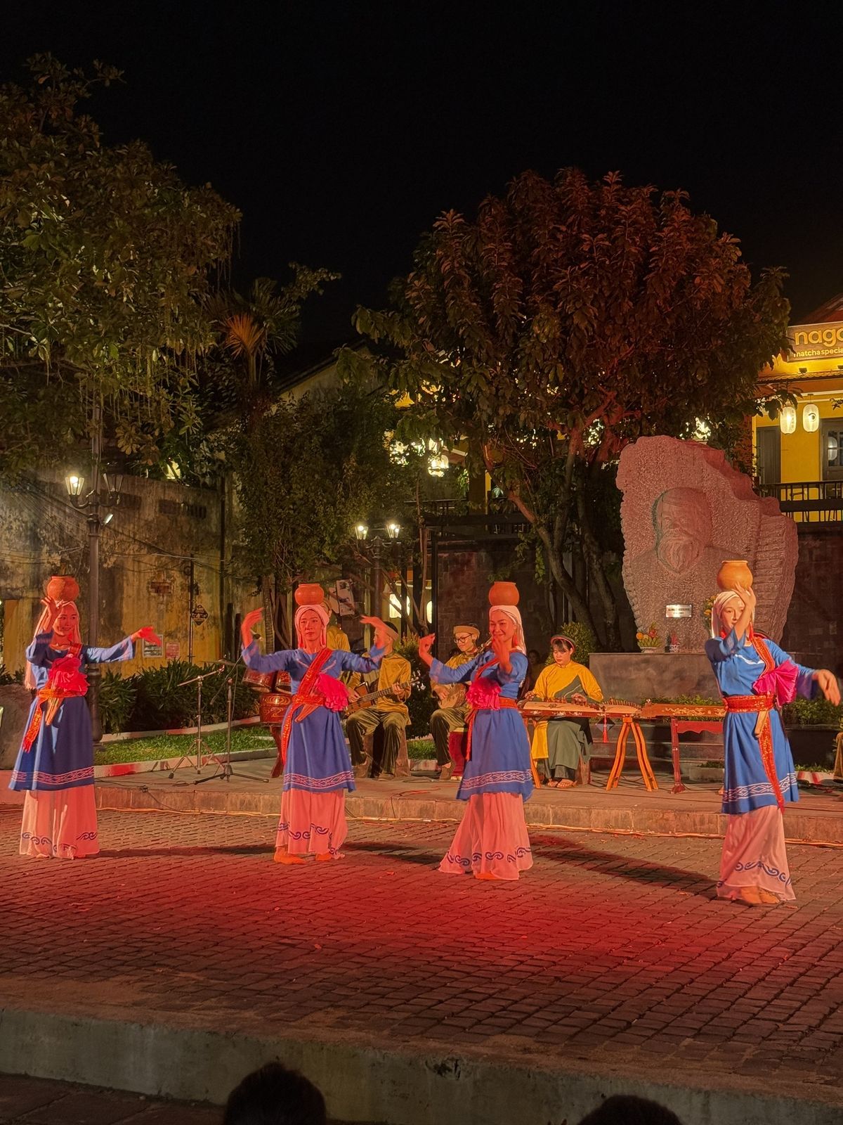 Four dancers with clay pots on their heads performing at Kazik Park on Tran Phu Street, Hoi An
