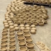Rows of handmade clay pots drying in the sun on a lane in Thanh Ha Pottery Village, Hoi An