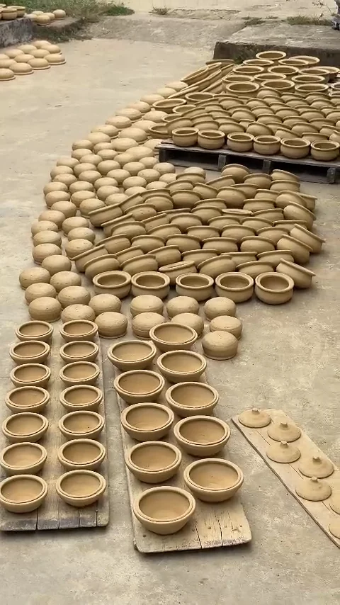 Rows of handmade clay pots drying in the sun on a lane in Thanh Ha Pottery Village, Hoi An