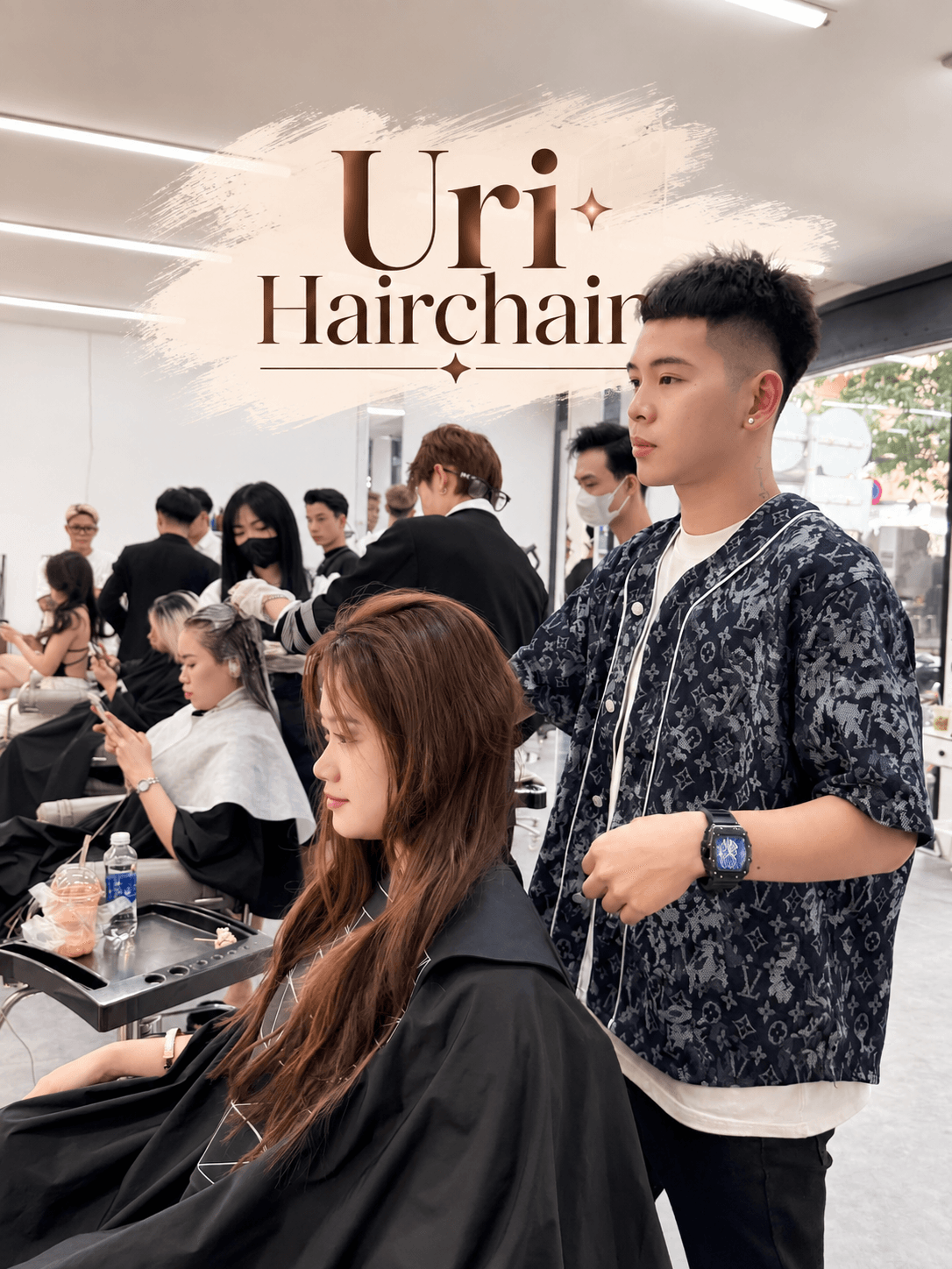 A stylist at work with clients in the busy, modern Uri Hairchain salon in Da Nang